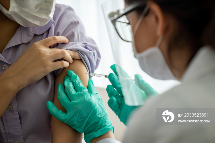 Young woman visits skillful doctor at hospital for vaccination . Covid 19 and coronavirus vaccination center service concept .