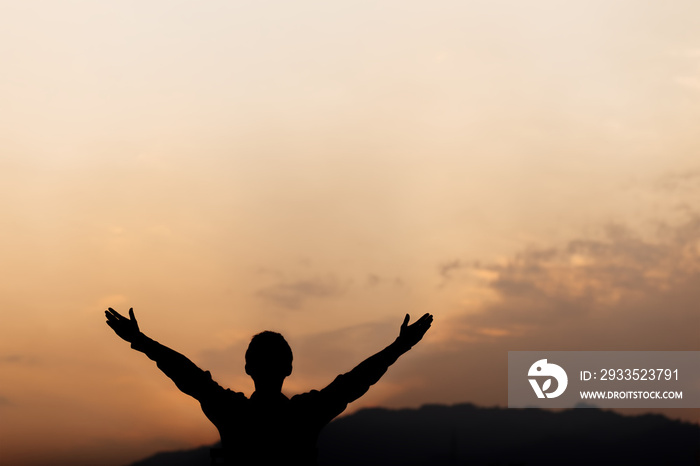 Silhouette of a man lift hands up and prayer at sunset. concept of religion.