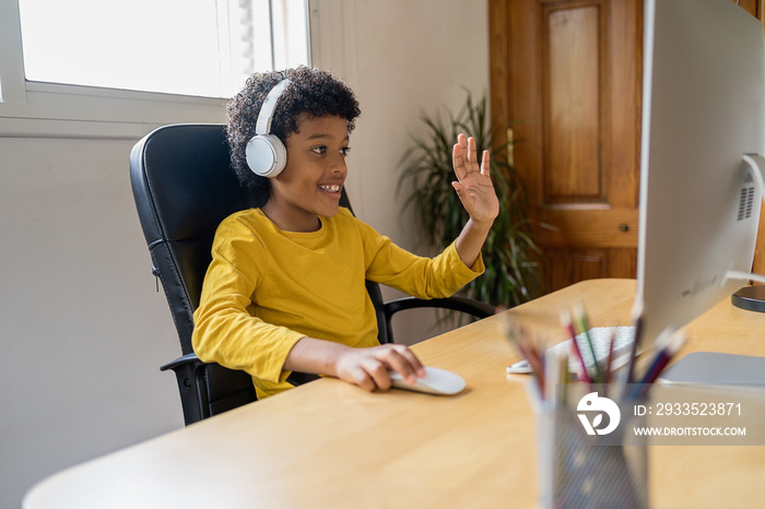 Happy african american boy talking via video conference with his family