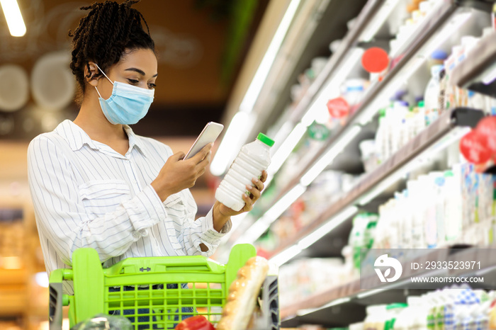 African Woman In Mask Using Smartphone Buying Groceries In Shop