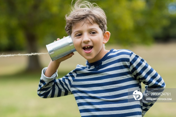 Boy listening through tin can phone