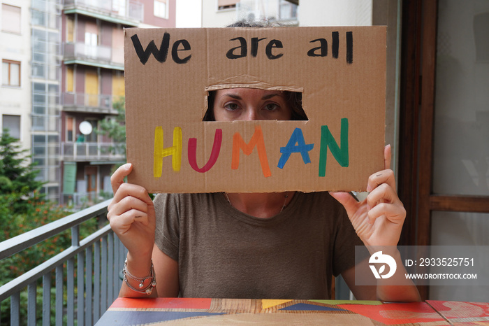 America USA - white latin girl holding sign we are all human protest and manifest after the killing by the American police - racism and social violence