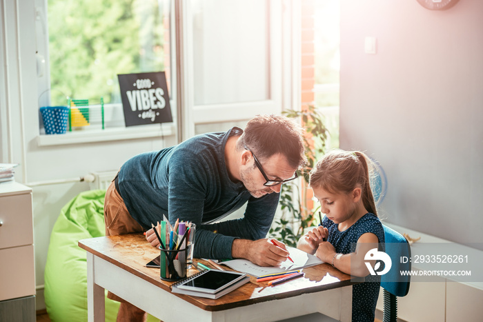 Father helping daughter to finish homework