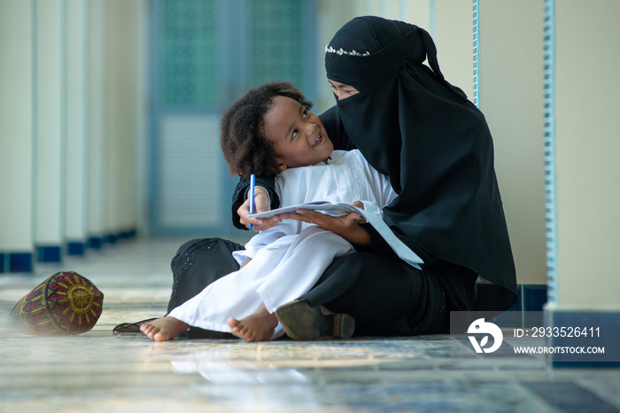 Muslim mother teaches her son to read Arabic, Looking at each other, relationship between Muslim mother and child, Mothers day