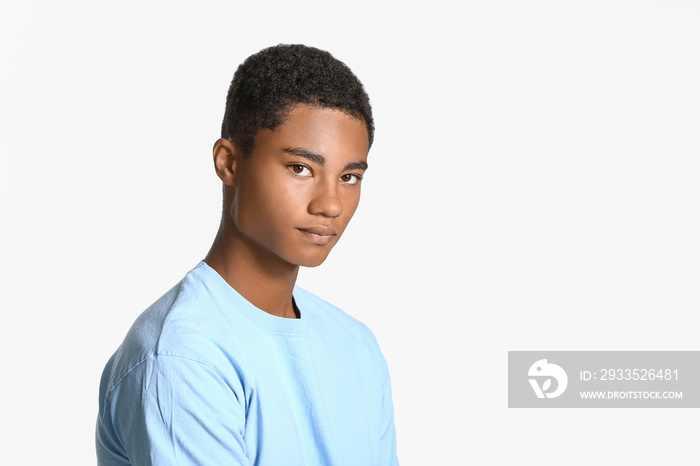 Sad African-American teenage boy on light background. Stop racism