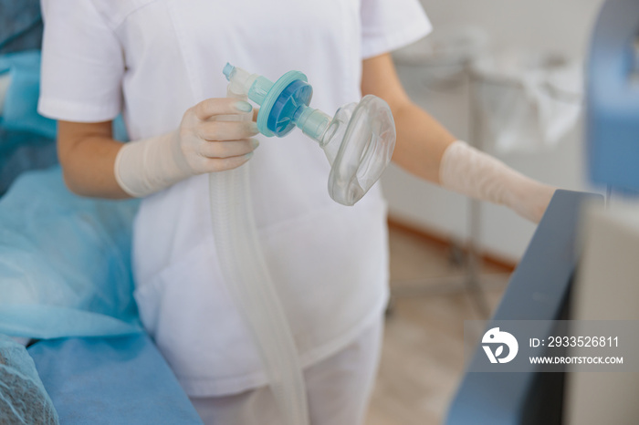 Nurse hands holding breathing mask in operating room before operation