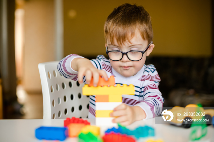 little ginger boy with glasses with syndrome dawn playing