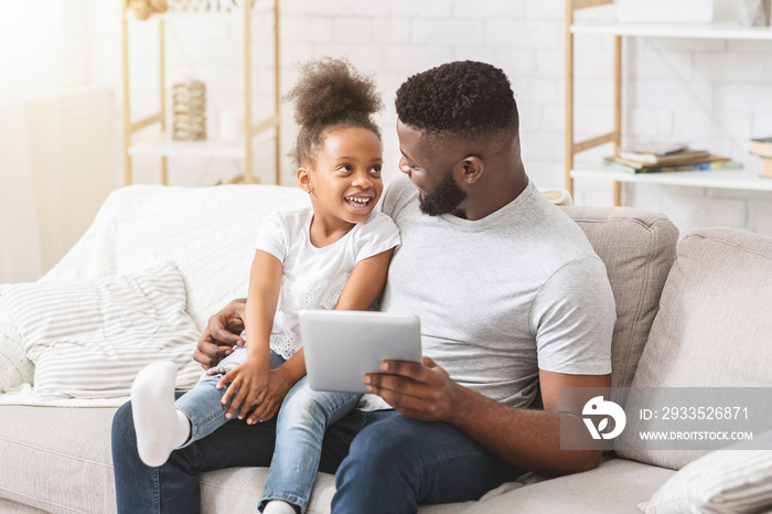 Father and daughter watching cartoons online on digital tablet