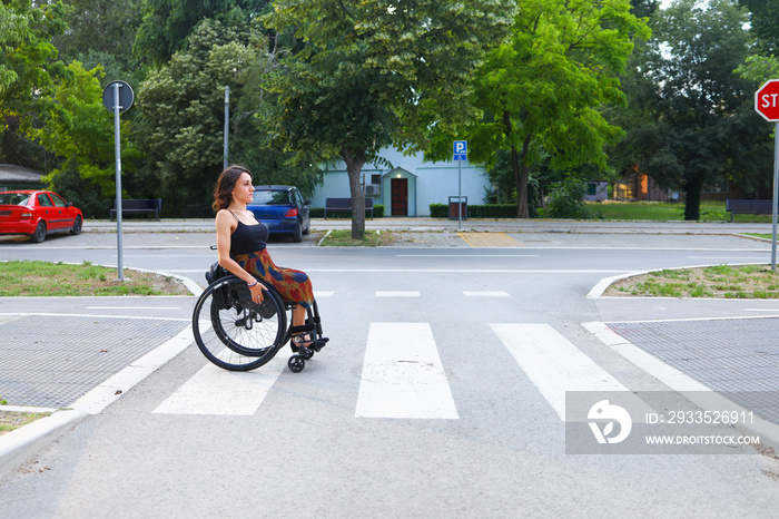 A woman in a wheelchair crossing the street safely.