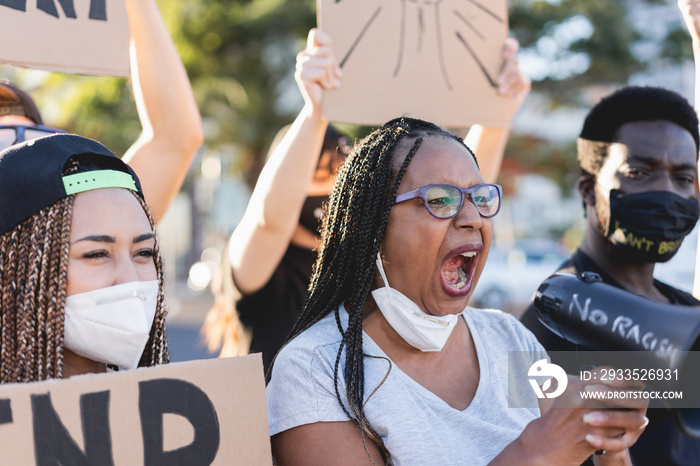 Group of people demonstrators protest in city street against racism wearing face masks - Equal rights fighting and black lives matter campaign concept - Focus on african woman face