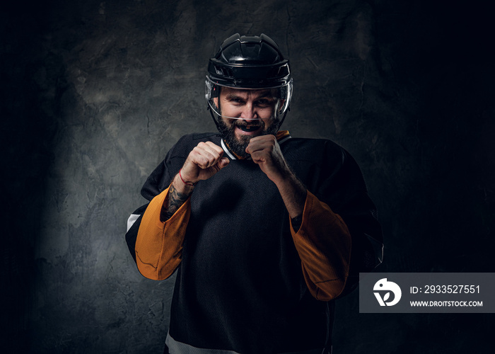 Toothless powerful hockey player in uniform is ready to fight, showing his fists.