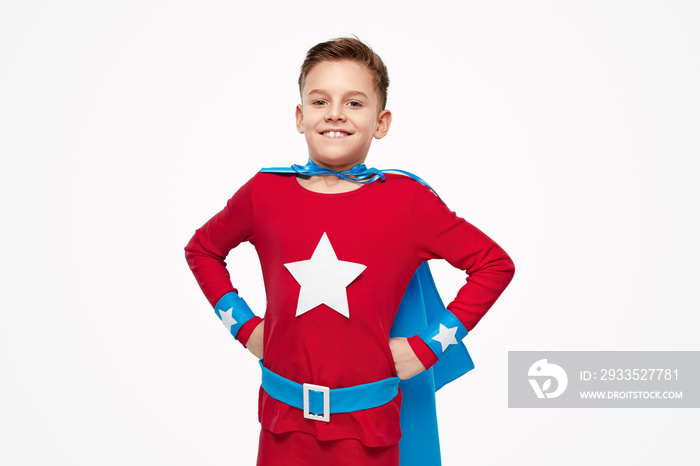 Smiling child in superhero costume in studio