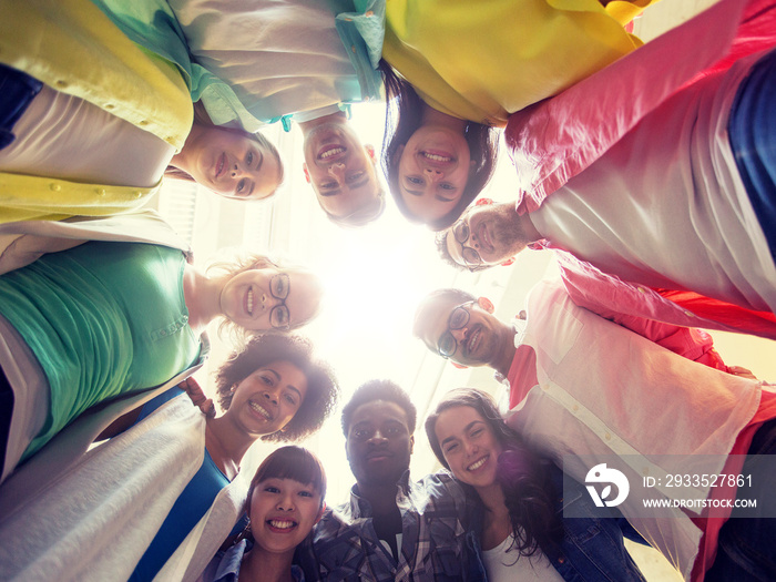 education, school, friendship and unity people concept - group of happy international students standing in circle