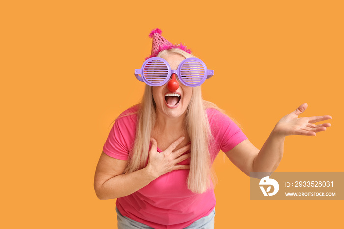 Mature woman in funny disguise on color background. April Fools Day celebration