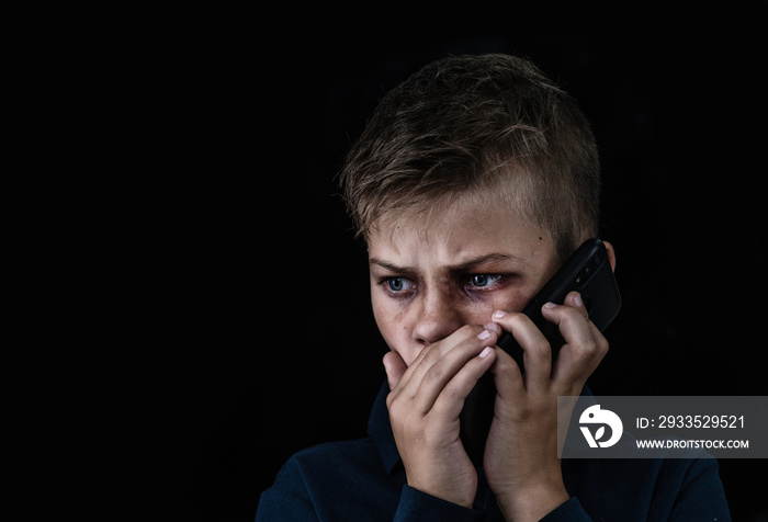 Boy victim of domestic violence and abuse asks for help by phone. Empty space for text