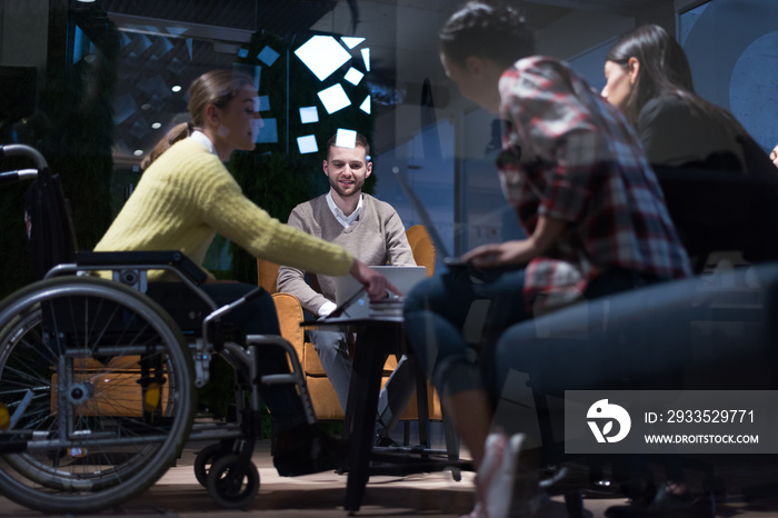 Handicapped young woman with colleagues working in office. She is smiling and passionate about the workflow. Performing in co-working space. Office people working together.