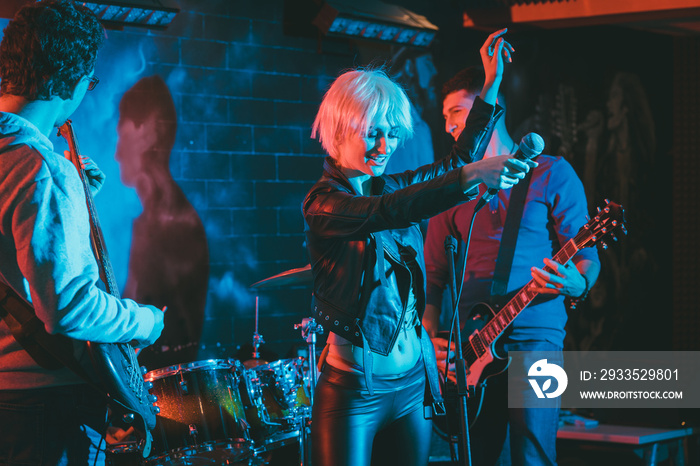 Band during gig making rock music on stage together