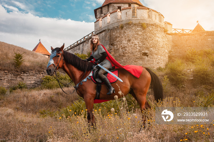 A beautiful girl with a sword in a medieval fantasy suit. A woman in a chain mail, crown, on a horse in combat ammunition. A girl riding a horse against the backdrop of the fortress.