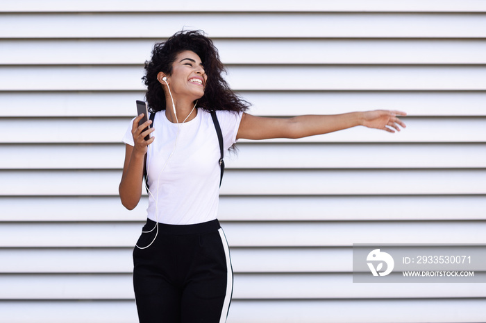 African woman listening to music with earphones and smartphone