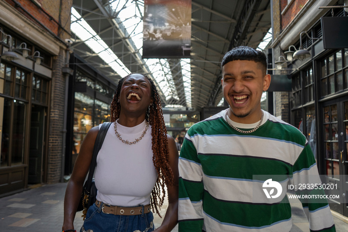 Laughing friends walking in cover market