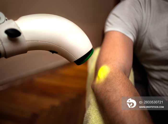 Patient having heat lamp physiotherapy treatment in home