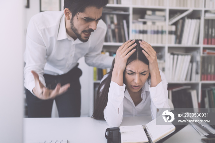 Businessman yelling at female colleague in office