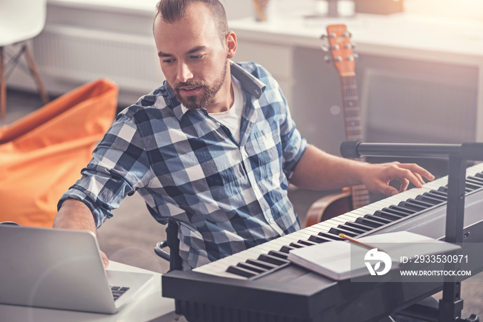 Confident accomplished musician using his laptop