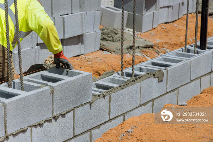 As a mason man is mounting a wall of aerated concrete blocks, he was laying for the wall