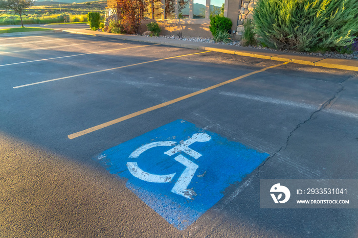 Handicapped parking space at a parking lot outside a building on a sunny day