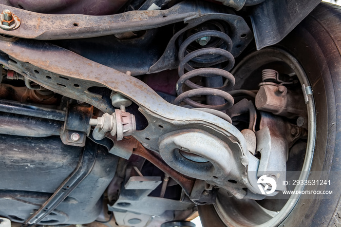 Extreme closeup of vehicle control arm, bushings and joints in a repair shop during inspection