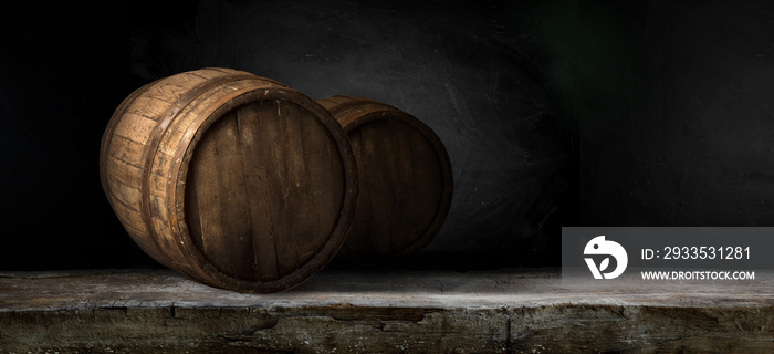 Excellent red wine bottles, wineglass, barrel and corkscrew on a rustic wooden table: traditional winemaking and wine tasting concept