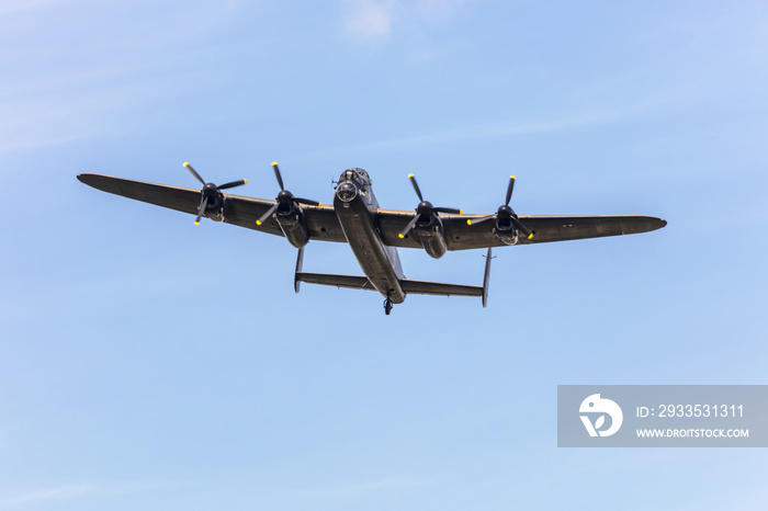 Old wartime air-plane Lancaster Bomber in flight during memorial WW2 day.