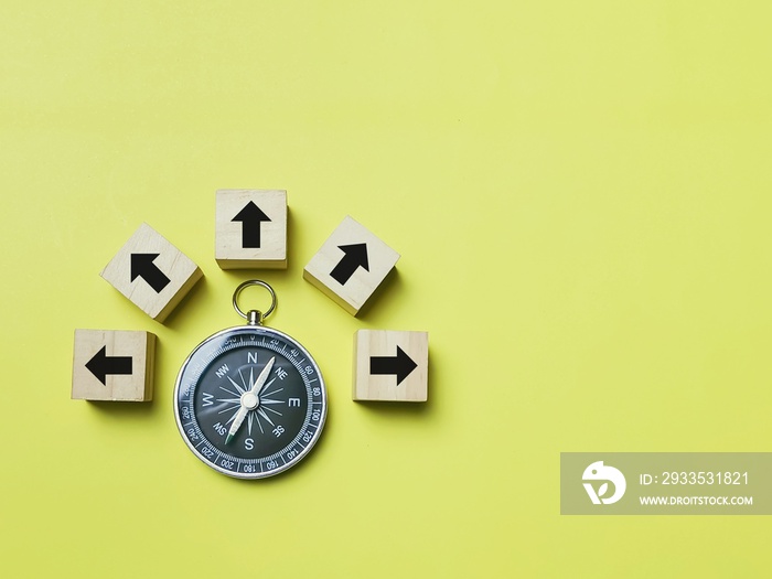 Top view magnetic compass with multiple arrow icons on wooden cubes.