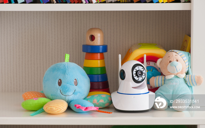 IP camera on the shelf with toys, serving as a baby monitor