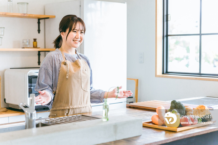 キッチンに立つエプロン姿の日本人女性