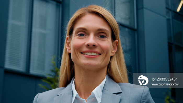 Headshot successful confident business woman leader professional manager standing outdoors looking at camera beautiful smiling caucasian businesswoman corporate employee posing near office building