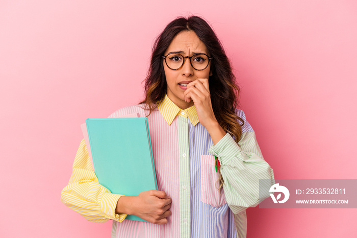 Young student mexican woman isolated on pink background biting fingernails, nervous and very anxious.