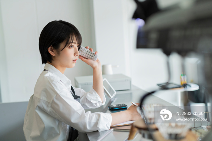 カフェ 電話をする女性スタッフ