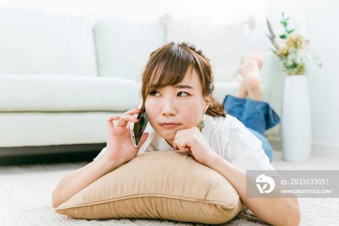 スマホで電話しながら怒る日本人女性（悩む）