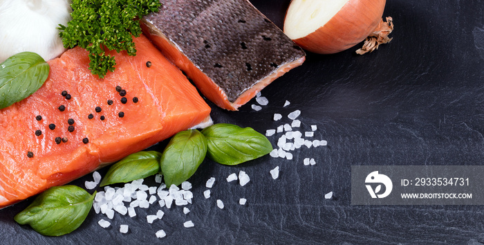 Wild king salmon fillet and fresh herbs on black stone setting