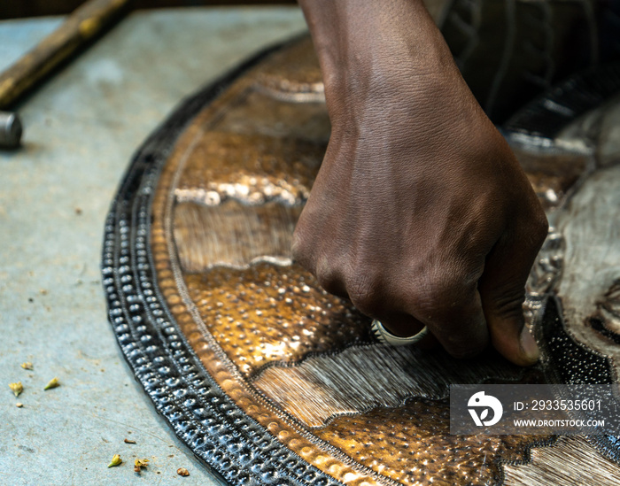 hand pressing on a piece of aluminium art