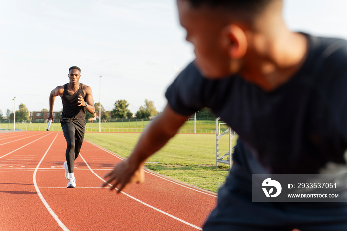 Two athletes running in relay race