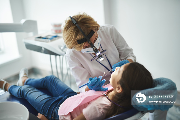 Young lady is being examined by dental professional