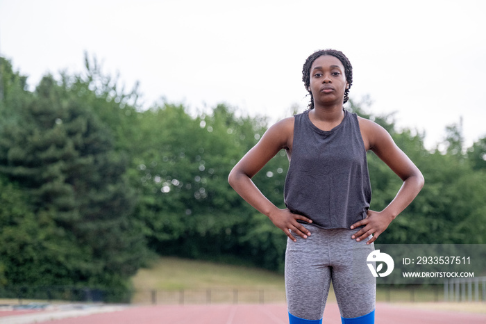 Portrait of athletic�woman standing on running track