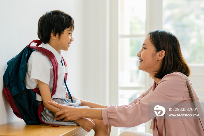 The mother prepares to send her son to school.