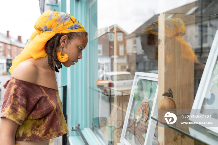 Young woman looking at store window