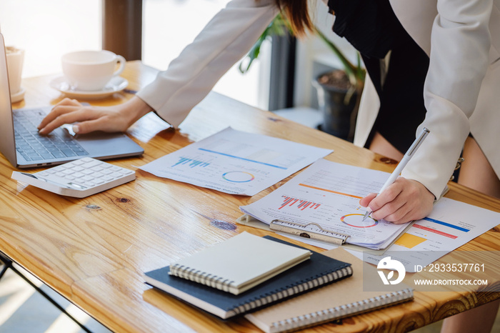 Young economists or accountants or financiers and investors are reviewing budget documents and using computers to study impact and risk assessments on corporate investment management.