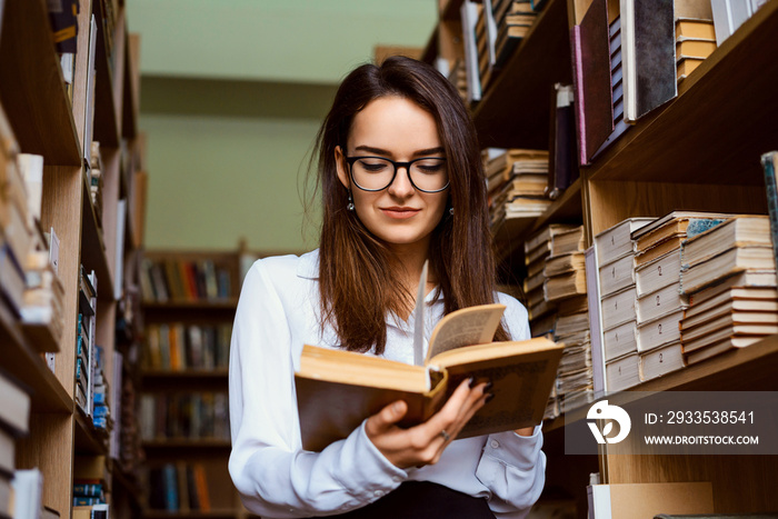 Female student at the library reading a book