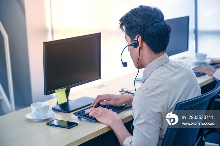 Young customer service men agent with headsets and computer working at office.