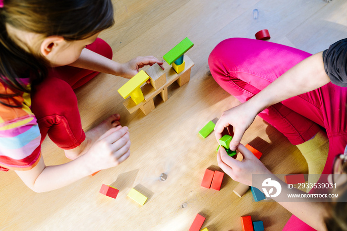 children playing with colorful wooden blocks - view from above